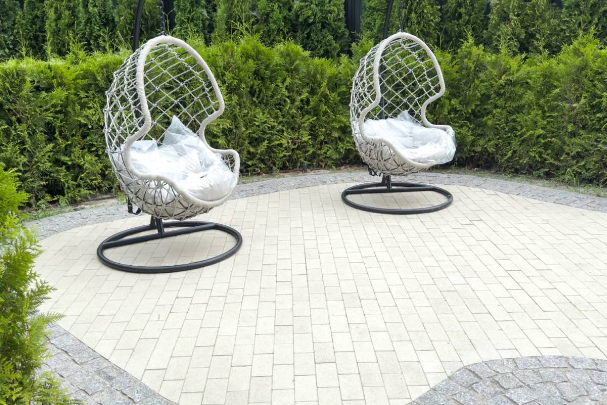 secluded garden stone patio with hanging basket chairs